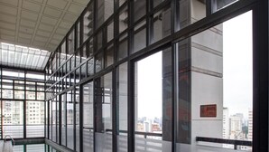 A long indoor swimming pool with clear glass walls and a tiled floor, surrounded by a high ceiling and large windows. - Radisson Blu São Paulo (São Paulo)