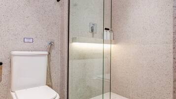 Une salle de bain moderne avec des toilettes, une douche à parois de verre et un sol en marbre.