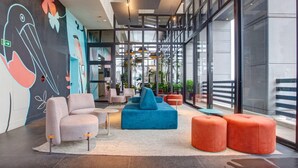 A modern lobby with seating areas, a large mural, and large windows. - Radisson Blu São Paulo (São Paulo)
