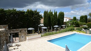 A swimming pool with lounge chairs and umbrellas, surrounded by trees and a stone wall. - Le Relais du Val d'Orbieu (Ornaisons)