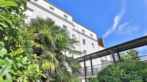 Un edificio de varios pisos con balcones y un cielo azul despejado.