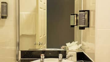 A bathroom with a sink, mirror, and towel rack.
