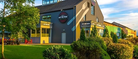 A modern building with a sign reading "OFF THE BONE" and a logo.