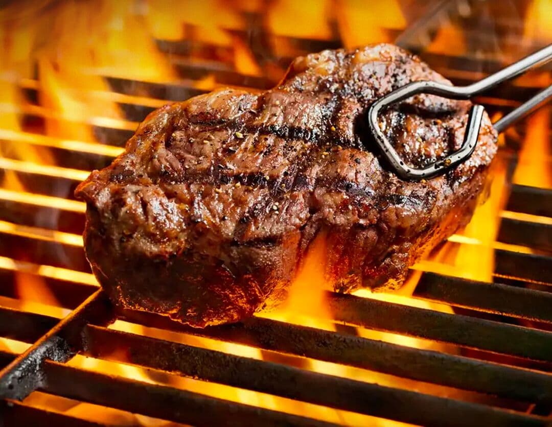 A steak being grilled on a grill.