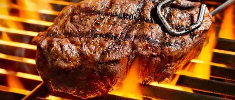 A steak being grilled on a grill.