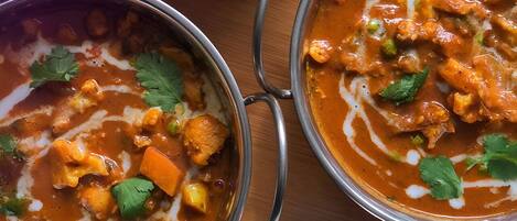 A table with two bowls of curry and a bowl of rice.