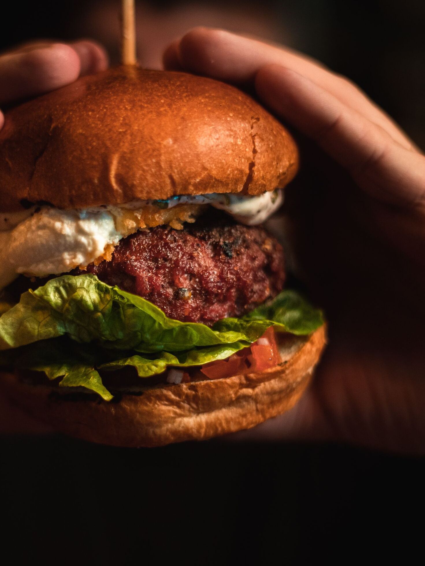 Primer plano de una hamburguesa con pan de sésamo, lechuga, tomate y una hamburguesa de carne.