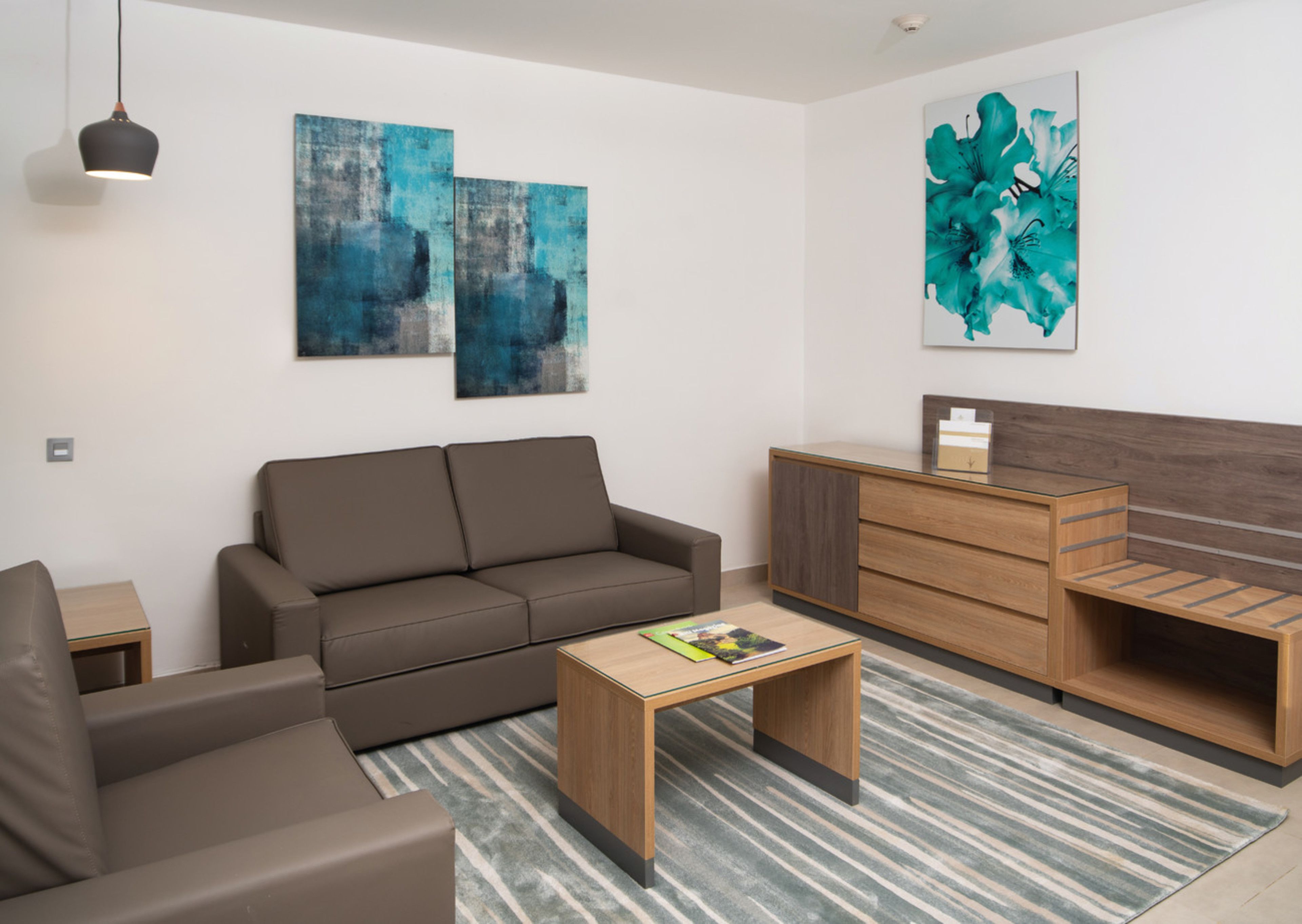 A modern living room with a sofa, a coffee table, and a wooden cabinet.