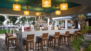 A bar area with wicker chairs, a counter, and hanging lamps. - Hotel Riu Palace Tropical Bay - All Inclusive (Negril)