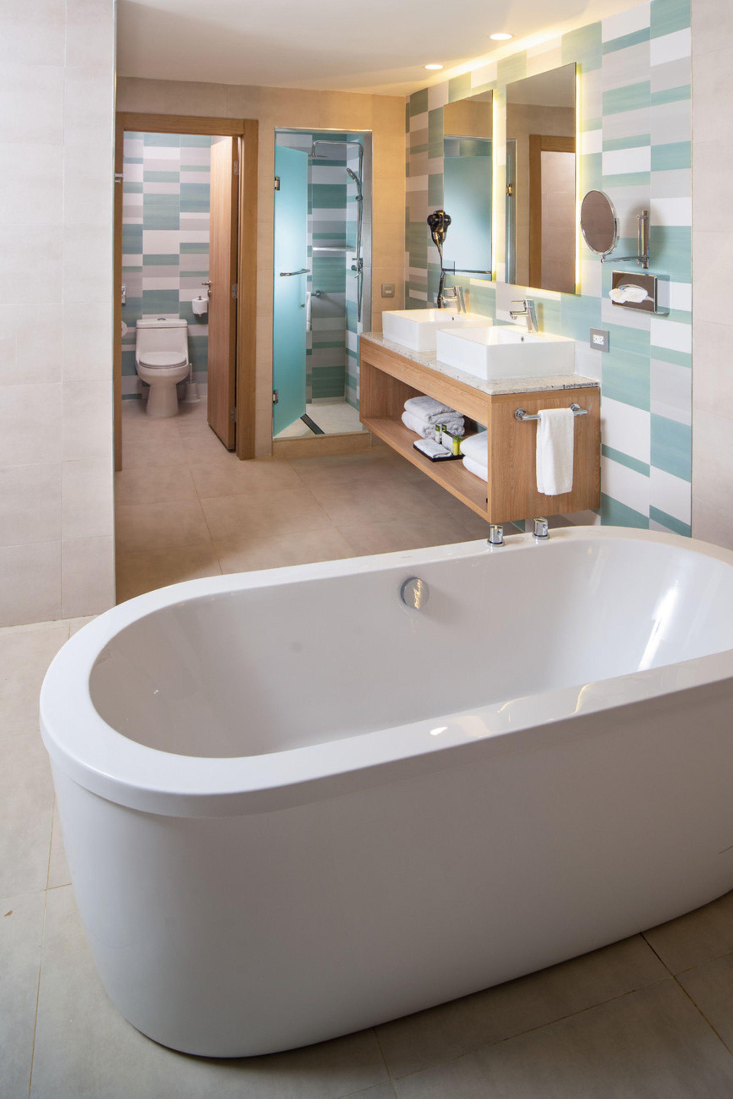 A modern bathroom with a freestanding bathtub, a vanity with a mirror, and a shower area.