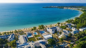 A coastal resort with multiple buildings, a beach, and a clear view of the ocean. - Hotel Riu Palace Tropical Bay - All Inclusive (Negril)