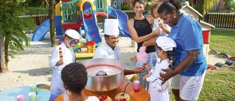 A group of people at a beachside event with a food station.