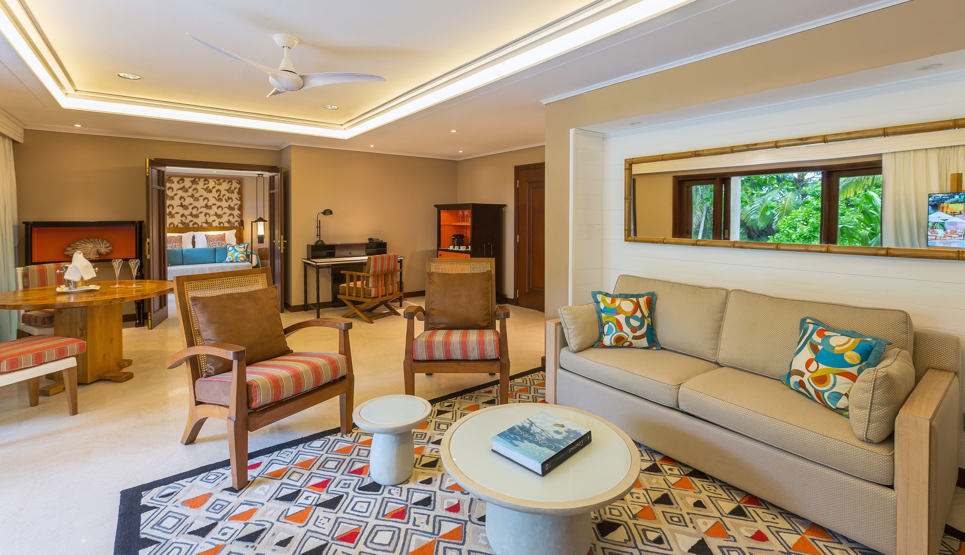 A well-lit living room with a sofa, armchairs, a dining table, and a small coffee table.