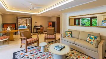 A well-lit living room with a sofa, armchairs, a dining table, and a small coffee table.