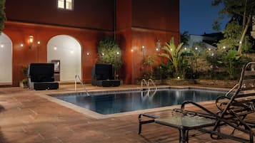 Alberca al aire libre y camastros