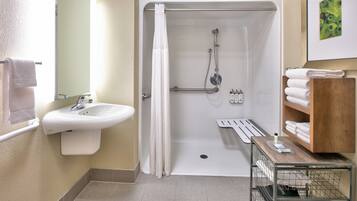 Ein Badezimmer mit Dusche, Waschbecken und Handtuchhalter.