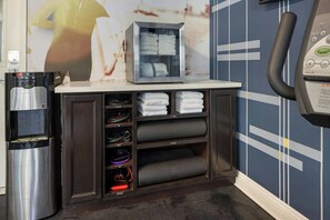 Ein Hotelzimmer mit Wasserspender, Handtuchwärmer und einem an der Wand befestigten Telefon.