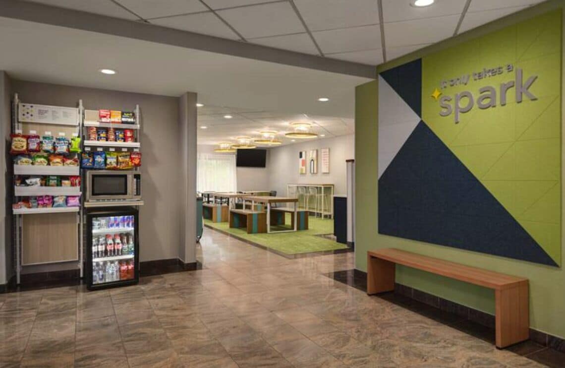A lobby area with vending machines, a seating area, and a wall with the text "spark".