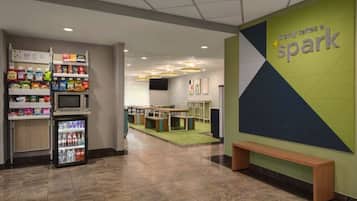 A lobby area with vending machines, a seating area, and a wall with the text "spark".