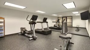 A gym with treadmills, elliptical machines, and weightlifting equipment.
