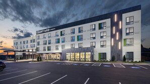 A Courtyard Marriott hotel with a modern design, multiple floors, and a parking lot with handicapped parking spaces. - Courtyard by Marriott Russellville (Russellville)