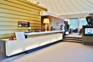Welcome to our reception area, featuring a sleek desk, flat-screen TV, and comfortable seating.