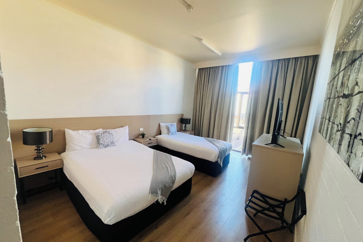 Escritorio, espacio para trabajar con laptop y cortinas blackout