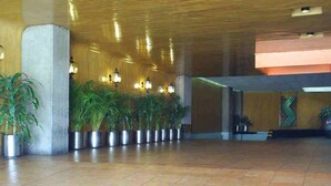 A spacious lobby with a tiled floor, potted plants, and a wooden ceiling. - Segovia Regency Hotel (Mexico City)