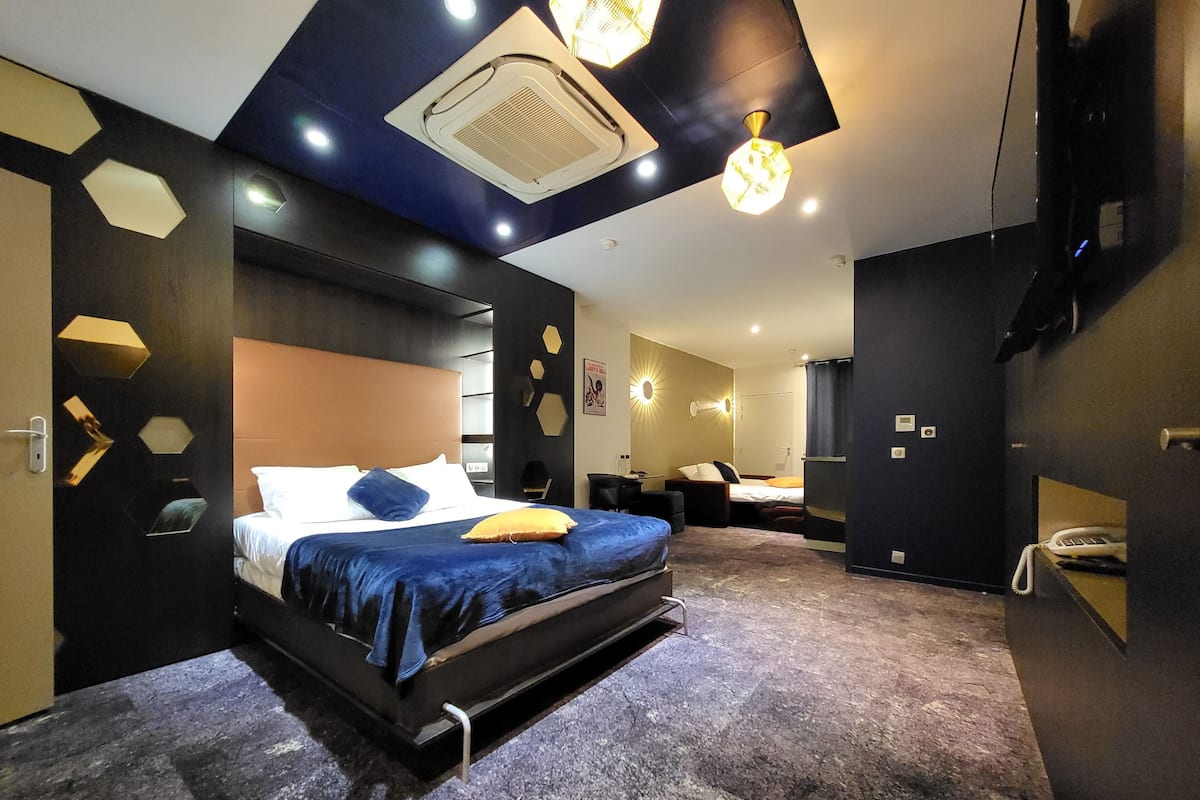 Une chambre moderne avec un lit, un bureau et une salle de bain.