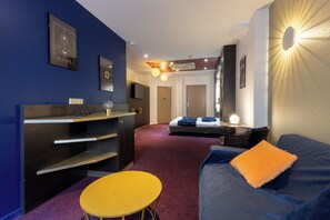 Habitación cuádruple Deluxe | Zona de estar | Televisión LCD de 26 pulgadas con canales por satélite, una televisión