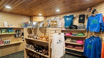 A retail store with wooden shelves displaying various items including plush toys, clothing, and accessories.