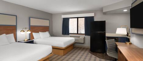 Une chambre d’hôtel avec deux lits, un bureau, une chaise, une télévision et un réfrigérateur.