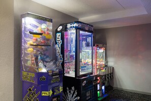 A row of arcade machines in a room with a patterned carpet.