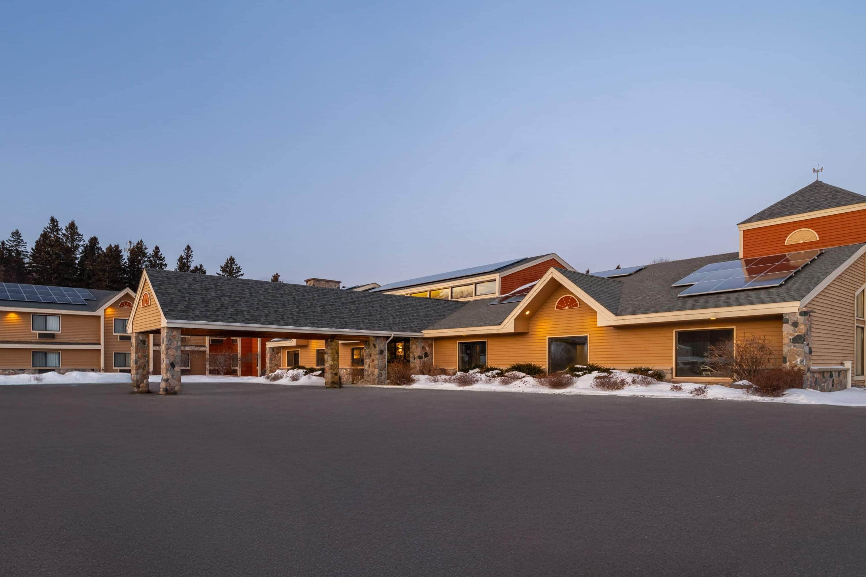 Ein Hotel mit Innenhof, mehreren Gebäuden und Solaranlagen auf den Dächern.