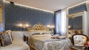 A luxurious bedroom with a large bed, a smaller bed, and a chair. - Hotel Santa Marina (Venice)