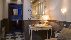 A hotel bathroom with a mirror, sink, and a small table with a vase of flowers. - Hotel Santa Marina (Venice)