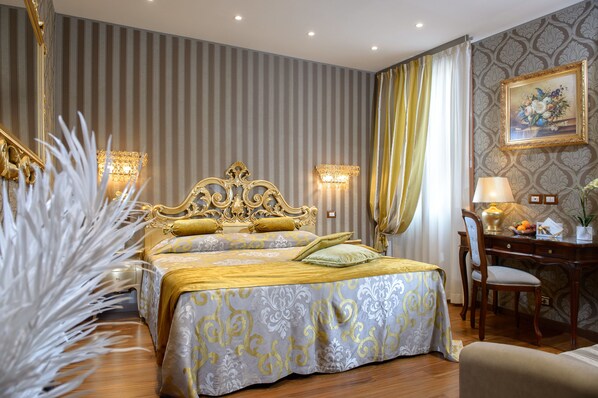 A luxurious hotel room with a large bed, a desk, and a chair.