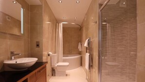 A modern bathroom with a large sink, toilet, and shower area. - Golden Lion Hotel (Stirling)