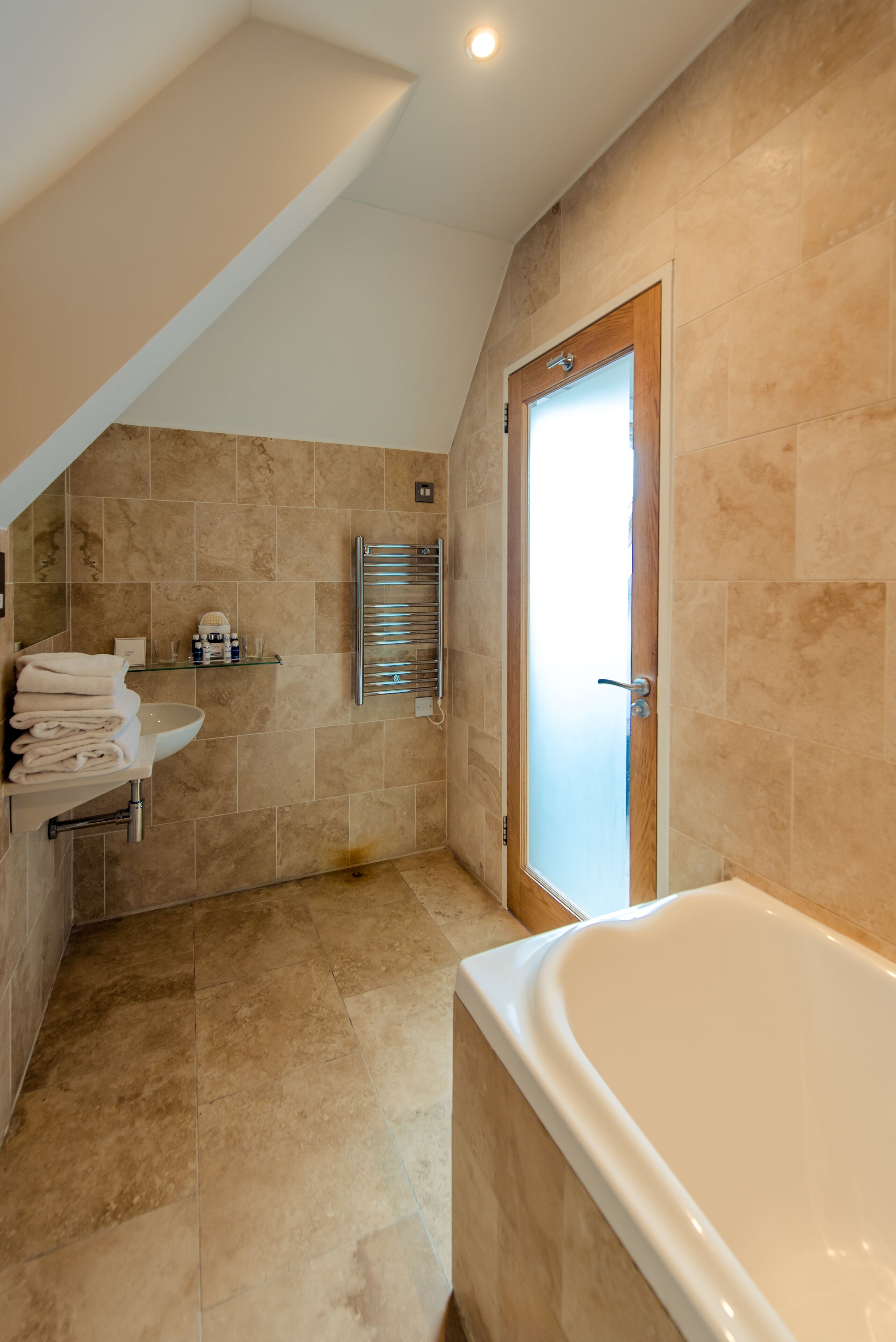 Een moderne badkamer met een bad, een wastafel en een handdoekhouder.