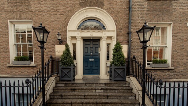 A brick building with a dark blue door, white-framed windows, and a stone staircase leading to the entrance. - Premier Suites Dublin Leeson Street (Dublin)