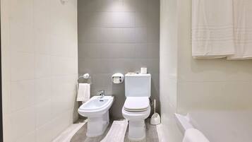 Un baño moderno con bidé, inodoro y bañera.