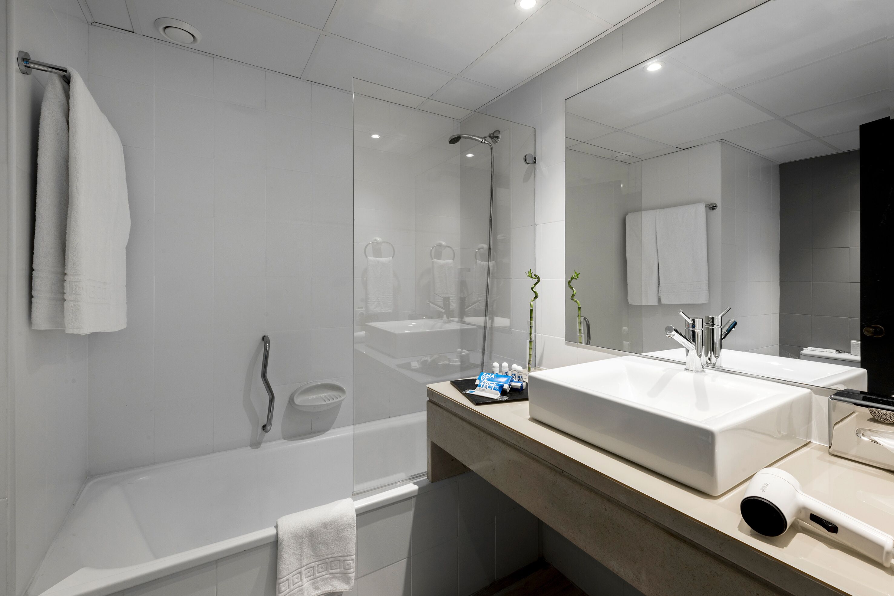 Ein modernes Badezimmer mit einer Badewanne, zwei Waschbecken und einem großen Spiegel.