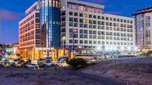 A multi-story hotel with a modern design, featuring a prominent curved glass facade and multiple balconies. - TRYP by Wyndham Lisboa Caparica Mar (Almada)