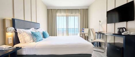 A hotel room with a bed, desk, and TV.