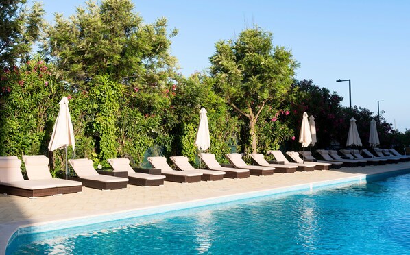 Piscine extérieure en saison, parasols, chaises longues