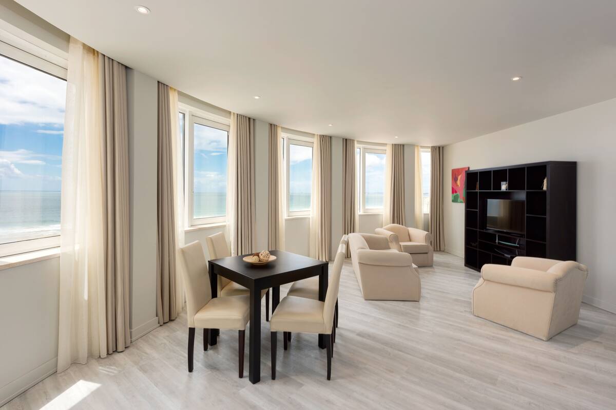 Una sala moderna con una mesa de comedor, sofás y un mueble para la televisión.