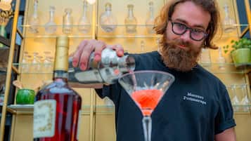A person pouring a drink into a martini glass.