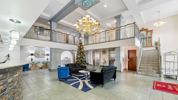 Un vestíbulo amplio con un árbol de Navidad, zona de estar y una escalera que sube a un piso superior.