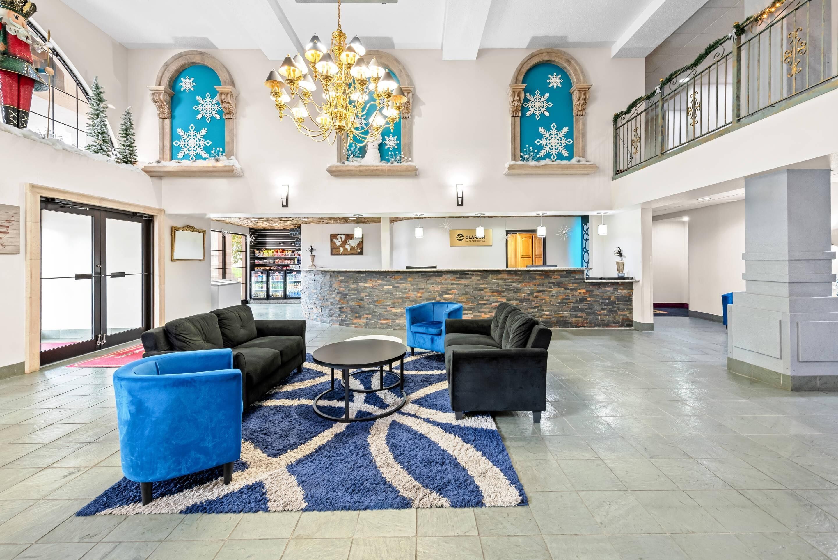 A spacious lobby with a chandelier, seating area, and a reception desk.