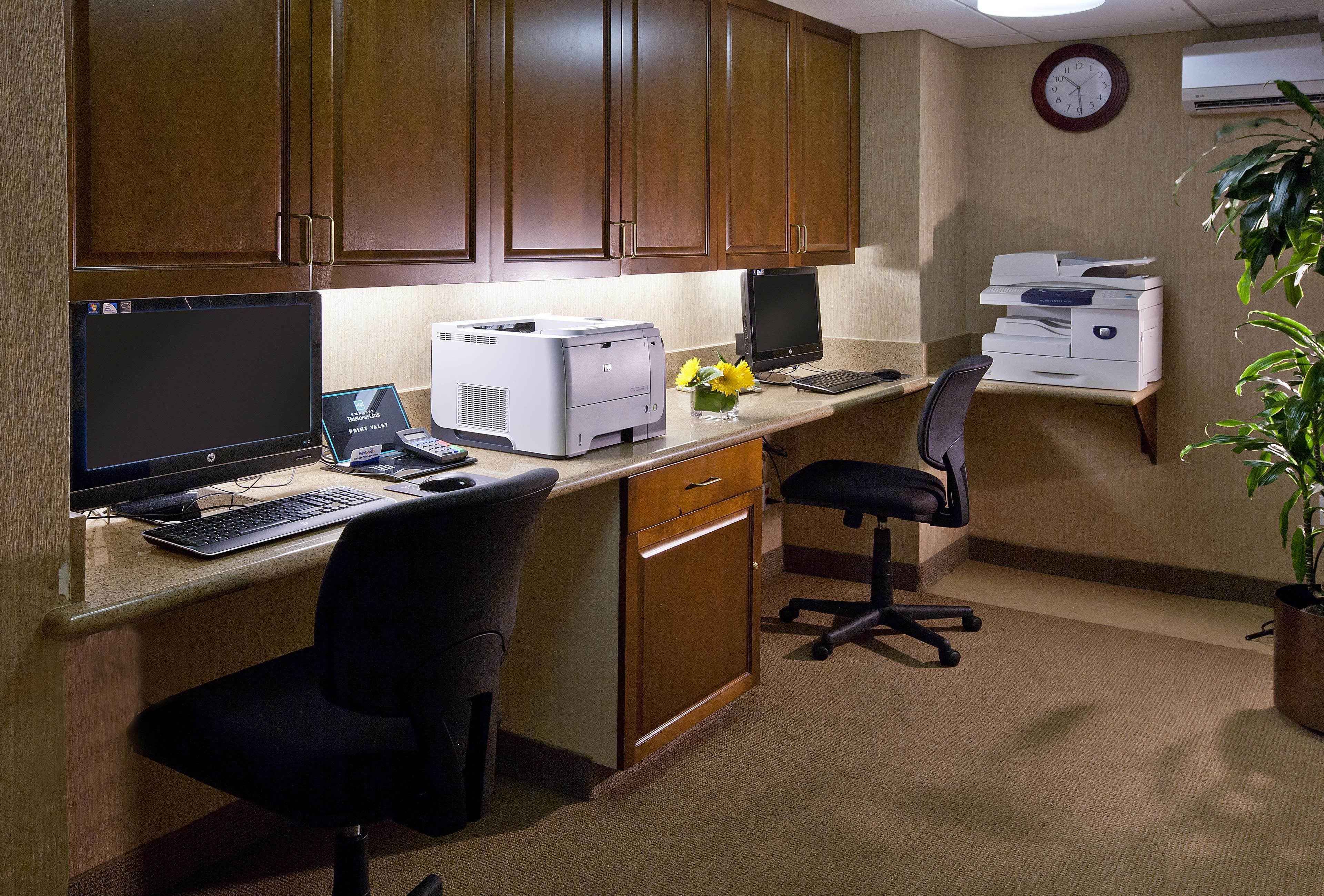 A home office with a desktop computer, printer, and office chair.